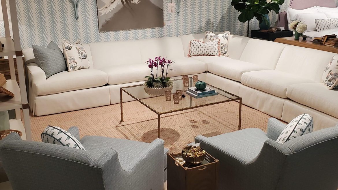 Interior designer in Atlanta A living room furnished with a sofa and coffee table, adorned with a flower vase, and embellished with wall decorations such as artwork or mirrors.